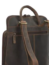 Mochila de cuero marrón oscuro, elaborada de forma artesanal, con bolsillo frontal con relieve de diseño botánico de hojas. Cuenta con compartimento para notebook y cierre.