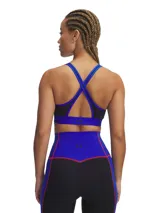 Sujetador deportivo de soporte medio con diseño de espalda cruzada. Presenta una base negra con detalles en azul y costuras en rojo, confeccionado en tejido elástico de alto rendimiento con tecnología de secado rápido y control de olores.