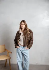 Campera de ecocuero color marrón, con forro interno de corderito sintético, cuello clásico, cierre frontal y bolsillos laterales.