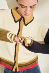 Cardigan de punto con diseño tricolor, de corte relajado, manga larga de tejido trenzado en contraste de color, cuello solapa tipo polo y cierre frontal de botones.