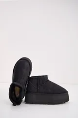 Bota corta tipo ugg de color negro, con plataforma alta y suela dentada. Presenta costuras reforzadas y tirador en la parte trasera.