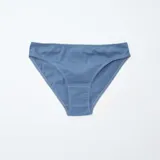 Pack de cinco braguitas de algodón, corte clásico, con borde de encaje blanco. Incluye dos lisas (azul y gris), una blanca lisa, una azul marino con estampado floral pequeño y una azul con estampado floral pequeño.