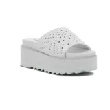Sandalia tipo mule de plataforma blanca, con tira ancha superior adornada con tachas metálicas plateadas. La suela presenta un borde dentado.