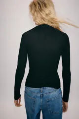 Camiseta de algodón negro de corte slim fit, con cuello subido, manga larga y cierre frontal de botones pequeños.
