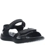 Sandalias negras de mujer, estilo casual, con tiras ajustables mediante velcro en el empeine y tobillo. Presentan una suela gruesa y ergonómica con plantilla contorneada. Se observa un logo grabado en la tira del tobillo.