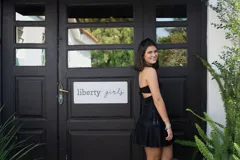 Minivestido negro con estampado abstracto en tonos grises y blancos. Presenta escote halter con abertura en el pecho, corte a la cintura y falda con volados.