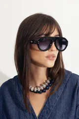 Lentes de sol estilo aviador con armazón grueso de policarbonato negro y cristales degradados con protección UV400.