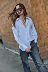 Camisa de manga larga con cuello solapa y cierre frontal de botones, confeccionada en tejido de algodón con estampado de cuadros vichy en tonos azul y blanco.