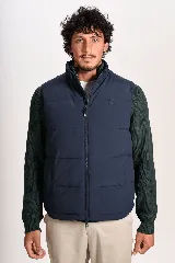 Chaleco puffer azul marino acolchado, con cuello alto, cierre frontal y bolsillos laterales.