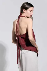 Top bordó con cuello halter cruzado y bordes deshilachados, de corte acampanado y caída suave.