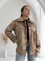 Sobrecamisa de pana color beige con estampado animal print, cuello camisero con solapa, cierre frontal con un botón, un bolsillo de parche en el pecho y puños y cuello con detalle de piel sintética.