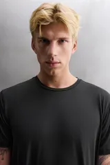 Camiseta de entrenamiento de ajuste regular, color verde oliva, confeccionada en tejido técnico ligero y elástico con estructura. Presenta cuello redondo, manga corta y costuras planas.