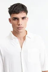 Camisa blanca de manga corta, corte oversize y cuello clásico.