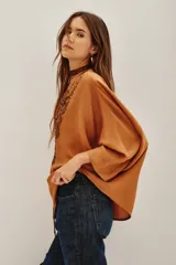 Camisa de viscosa color crema, con cuello mao y cierre frontal de botones. Presenta un delicado bordado floral en el frente y mangas tres cuartos con puños rectos.