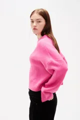 Sweater de tejido de punto color negro, con cuello redondo a la base, mangas largas y diseño holgado.