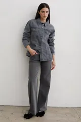 Chaqueta de denim color marrón, con corte entallado en la cintura, cierre frontal con botones metálicos y bolsillos superiores con solapa.
