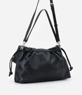 Cartera tipo shoulder bag de tamaño grande, confeccionada en poliuretano con acabado que imita el cuero. Presenta un diseño desestructurado con solapa superior, cierre mediante cordón de ajuste y detalles metálicos plateados en el frente. Incluye correa ajustable para llevar al hombro o cruzada.