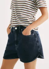 Short de jean de tiro medio, color azul oscuro, con diseño de corte curvo en los laterales y bolsillos frontales.