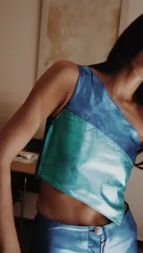 Top color crema de cuero sintético, con un solo tirante ancho y corte asimétrico.