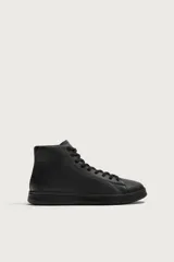 Zapatilla deportiva tipo botín para hombre, confeccionada en piel lisa de color negro, con detalles de pespuntes, cordones al tono y suela plana.