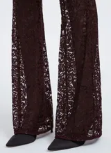 Pantalón largo acampanado de encaje color borgoña con hilos metálicos, cintura alta y cierre lateral invisible.