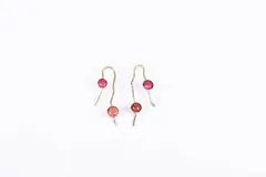 Aros colgantes dorados con engarce de piedras redondas en tonos rosados.