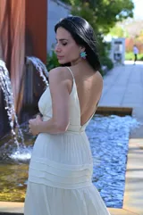 Vestido largo color amarillo manteca con breteles finos, escote en V y falda con volados.