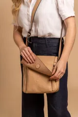 Bandolera de diseño simple con tapa frontal, confeccionada en material símil cuero. Cuenta con correa ajustable, división interna y bolsillos internos para mayor organización.