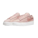 Championes Nike Blazer Low Platform de color rosado con textura de tejido tipo waffle. Presenta el icónico swoosh de Nike en el lateral en un tono rosado más intenso, cordones al tono y una suela de plataforma blanca de goma.