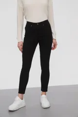 Pantalon de jean negro, corte skinny y tiro medio, con cierre frontal y bolsillos laterales.