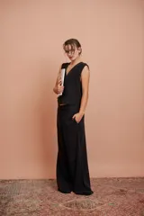 Pantalón negro de corte ancho con pinzas y pretina ancha.