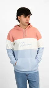 Hoodie con diseño tricolor en bloques horizontales, combinando tonos salmón, blanco y celeste. Presenta capucha con cordones ajustables, bolsillo frontal tipo canguro y el nombre de la marca bordado en el centro del pecho en color celeste.