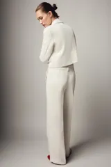 Pantalón de tiro alto con pernera recta y raya planchada en el delantero. Cuenta con bolsillos laterales y cierre frontal con cremallera y botón.