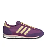 Championes Adidas modelo SL 72 OG W, color morado con tres franjas laterales color crema/beige. Presentan puntera y talón en gamuza morada, forro interior beige y detalles en rosa pálido en la entresuela. Cordones amarillos.