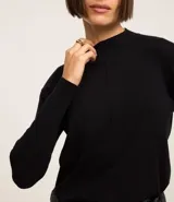 Suéter verde oscuro de punto con cuello alto y mangas largas.