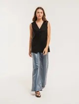 Chaleco color crema de lino con corte sastrero, largo a la cadera, forro interno, botones delanteros, silueta levemente entallada y tajo cruzado en la espalda.