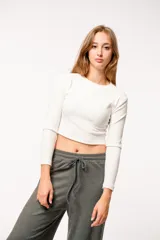 Top blanco de felpa con lycra, corte crop y mangas largas.
