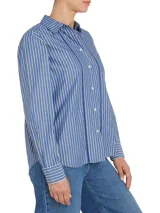 Camisa de manga larga a rayas verticales azules y blancas, con cuello inglés y corte amplio. Presenta detalles distintivos de la marca Tommy Hilfiger y logo bordado en el puño.