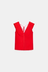 Top rojo de popelín con escote en V pronunciado, mangas sisa y pespuntes en contraste. Cuenta con tirantes finos cruzados y lazada en la espalda.