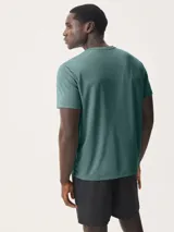 Camiseta deportiva azul marino de manga corta y cuello redondo, con un pequeño logo blanco bordado en el pecho.