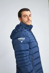 Campera puffer Mistral de corte regular, con cierre frontal completo, bolsillos laterales con cierre y capucha desmontable. Presenta logo de la marca en goma en el pecho.