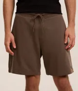 Bermuda masculina de corte slim, confeccionada en tejido de algodón con felpa. Presenta cintura elástica con cordón ajustable, bolsillos laterales y una pequeña etiqueta aplicada en el ruedo.