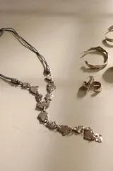 Collar largo de diseño artesanal compuesto por piezas irregulares de alpaca maciza unidas por eslabones, montado sobre un cordón de algodón natural con sistema de nudo corredizo ajustable.