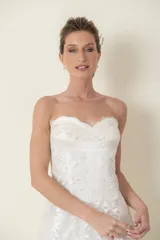 Vestido blanco strapless de tul drapeado con cintas de satén en la falda y corsé de encaje bordado.
