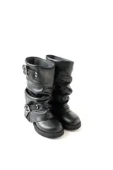 Bota de cuero negro con caña media arrugada, dos correas con hebillas plateadas y taco bajo.