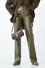 Pantalón de tiro medio con calce recto y largo hasta el tobillo, confeccionado en material con efecto piel o vinilo, color verde oliva brillante.