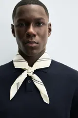 Pañuelo cuadrado de algodón color beige/tostado con doble borde cosido en hilo negro contrastante.