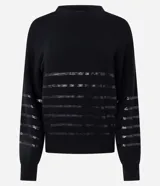 Suéter de punto color negro con cuello redondo y mangas largas. Presenta un diseño con franjas horizontales decoradas con lentejuelas del mismo tono en el cuerpo y las mangas.