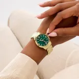 Reloj analógico Guess modelo Winni con caja y malla de acero inoxidable en tono dorado. Presenta una esfera de 34 mm en color verde con acabado sunray, números arábigos en las posiciones 3, 6, 9 y 12, y manecillas doradas.