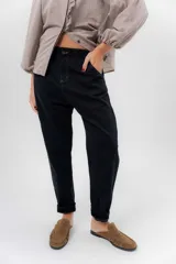 Pantalón de gabardina de algodón color negro, con fit medio barrel, tiro bajo y detalles en pana lisa. Cuenta con bolsillos laterales y traseros, y ruedo diseñado para usar vuelto.